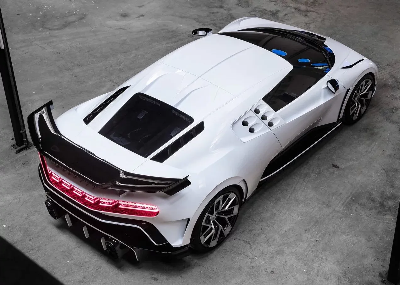 Białe Bugatti Centodieci z czarnymi akcentami i czerwonymi światłami. Zastanawiasz się, ile kosztuje Bugatti Centodieci?