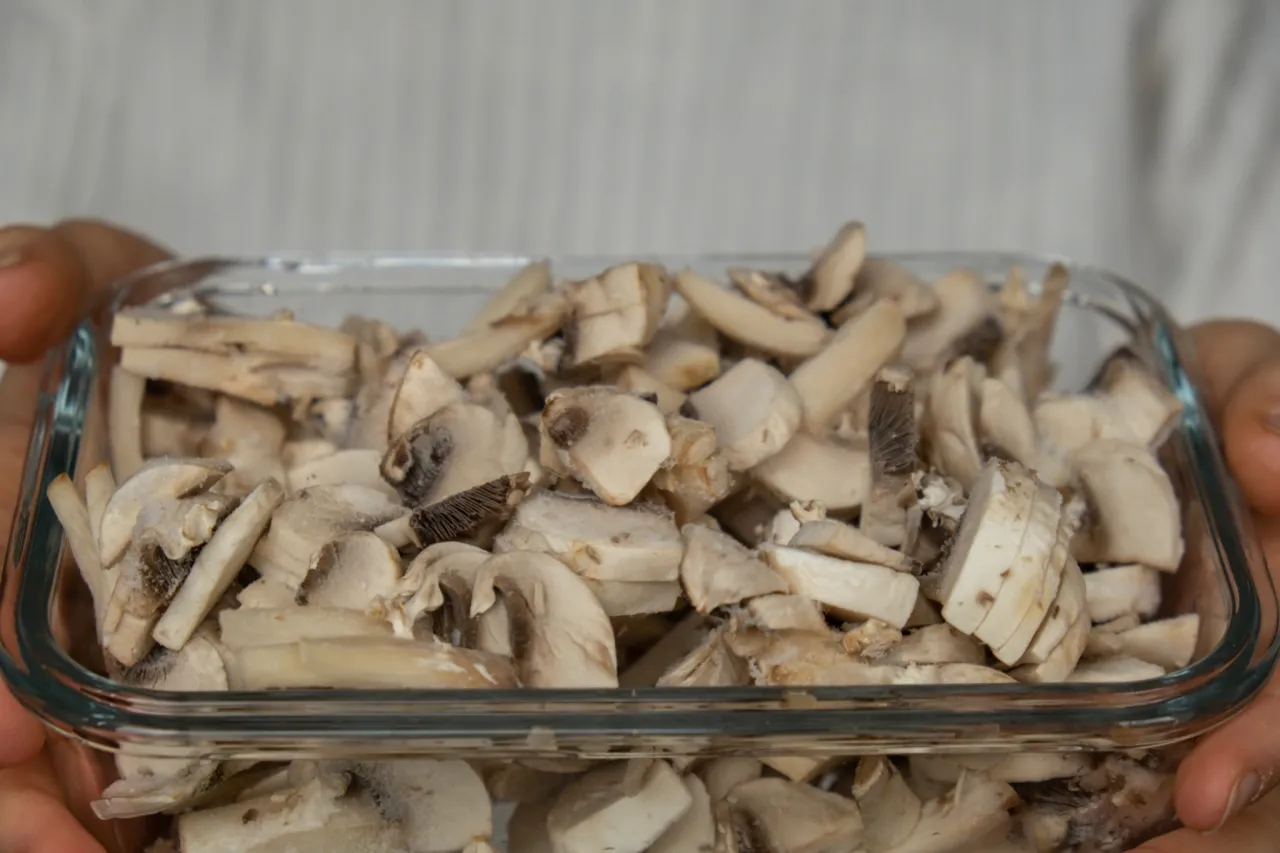Pokrojone pieczarki w szklanym pojemniku, gotowe do mrożenia. Czy można mrozić pieczarki? Tak, to świetny spos&oacute;b na ich przechowywanie.