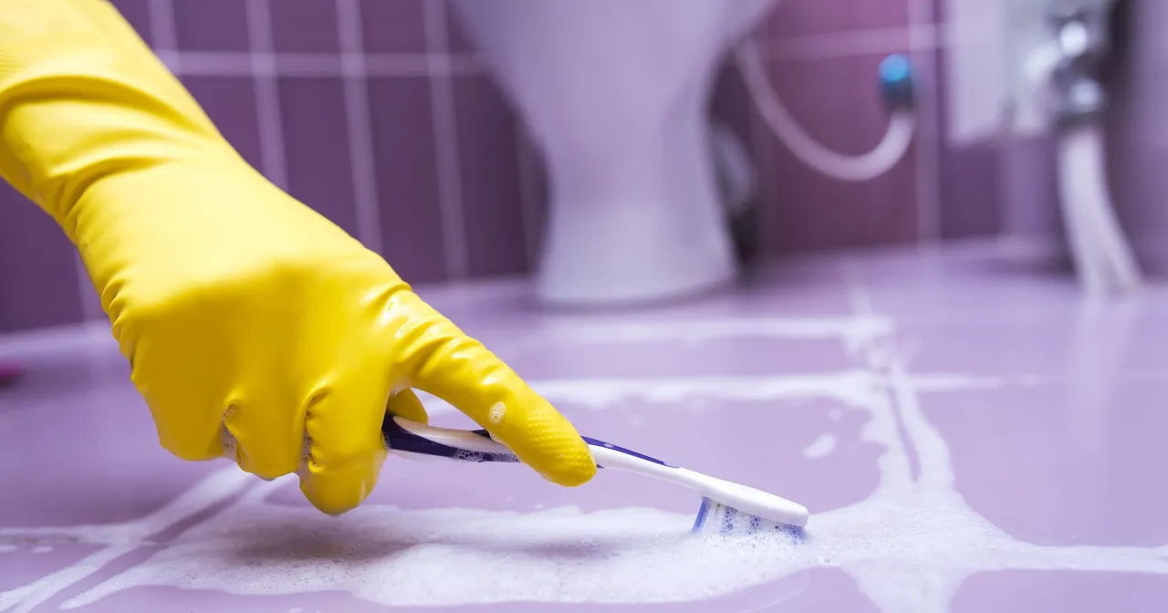 Kobieta czyści fugi pastą z sody