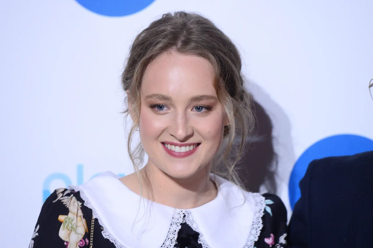 Uśmiechnięta Maria Kowalska, aktorka, w czarno-białej sukience z kołnierzykiem.