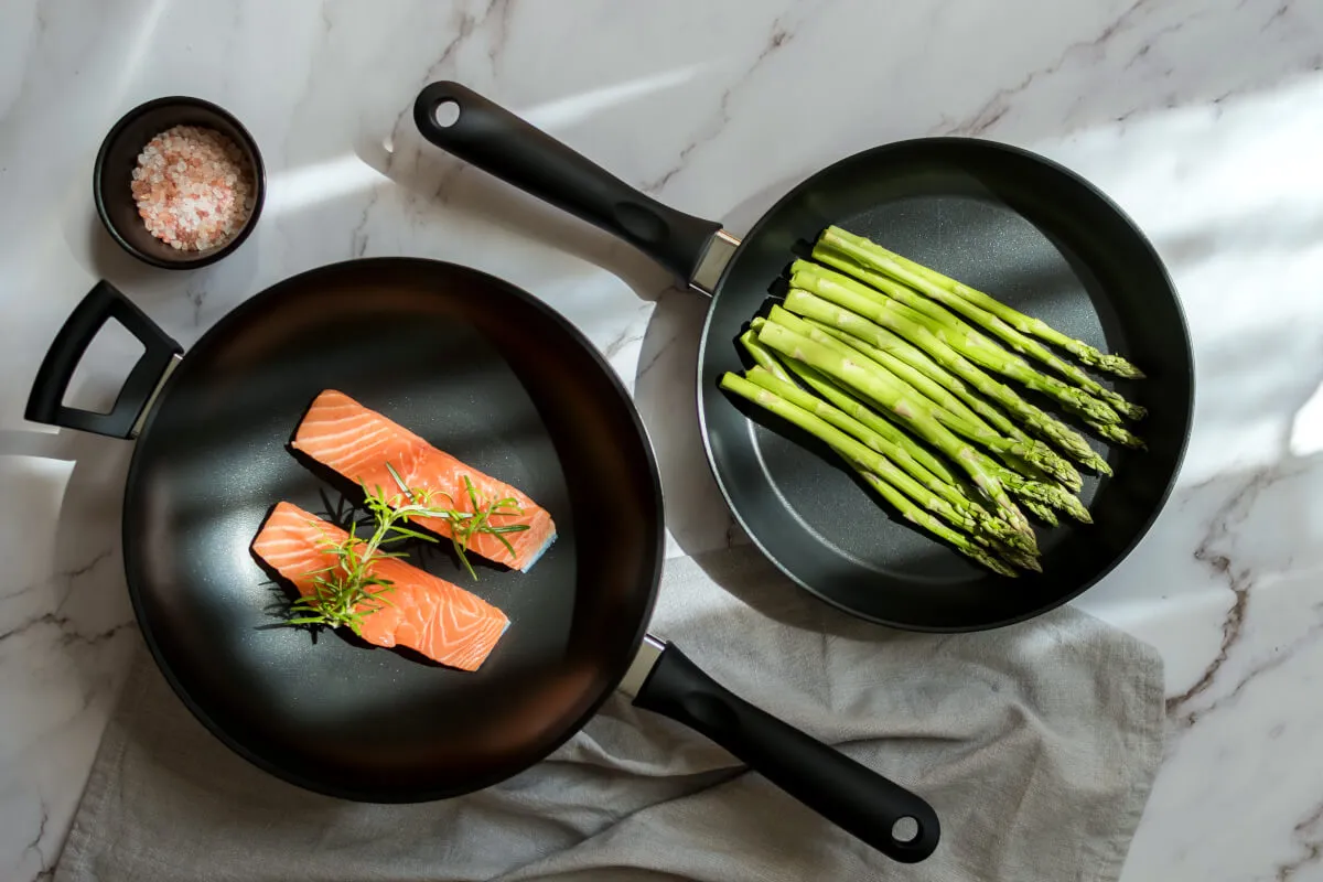 Dwa kawałki łososia z rozmarynem i pęczek szparag&oacute;w na patelniach. Czy to najlepsza patelnia najzdrowsza blog?