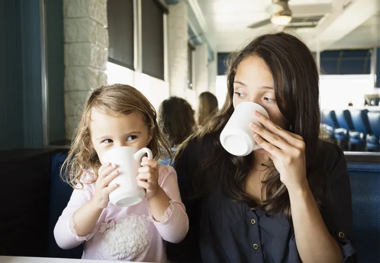 dziecko z kubkiem kawy zaniepokojony rodzic