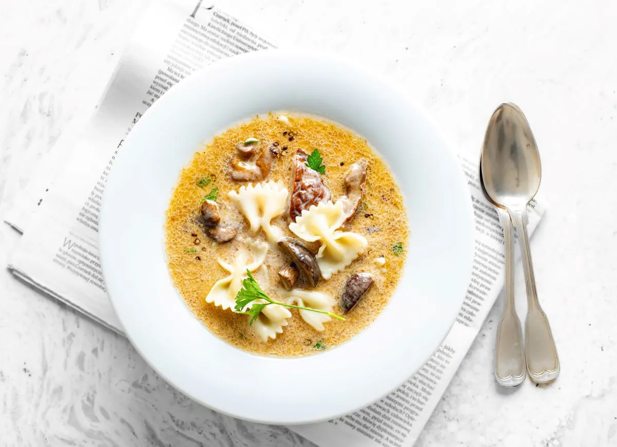 Kremowa zupa grzybowa z makaronem farfalle, idealna na jesienne dni. Jakie przyprawy do grzybowej? Z pewnością pieprz i natka pietruszki.