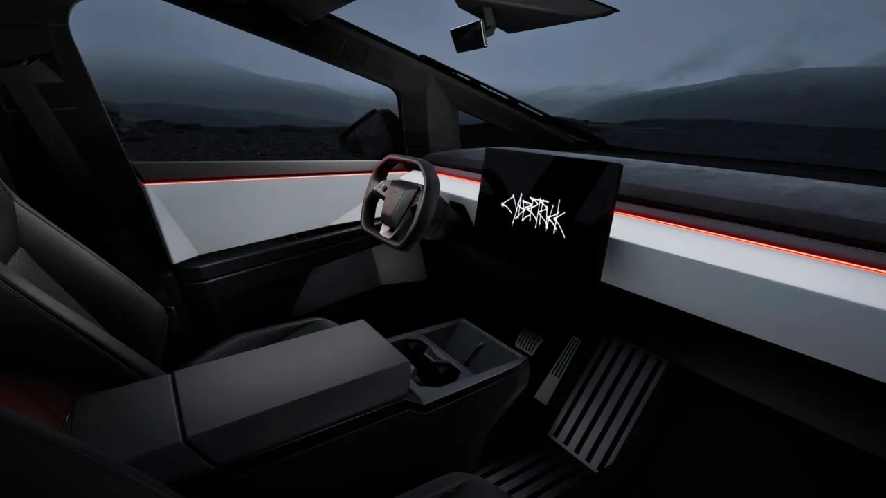 Wnętrze Tesli Cybertruck: minimalistyczna deska rozdzielcza z ekranem, kierownica i czerwone podświetlenie.