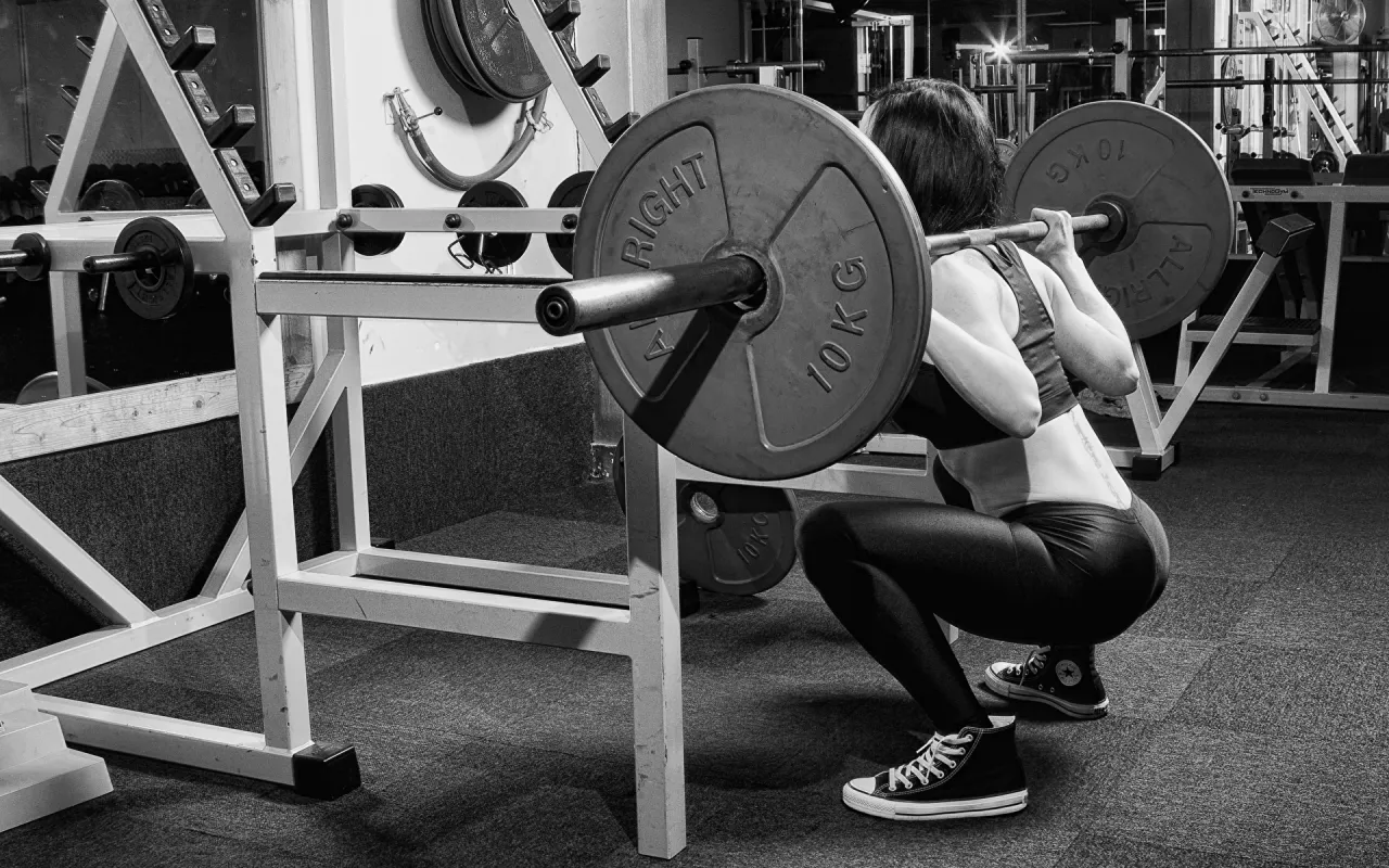 Kobieta wykonująca przysiady w domu