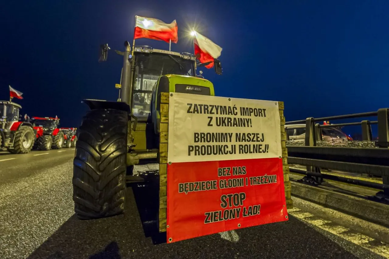 Traktor z polskimi flagami i transparentem 