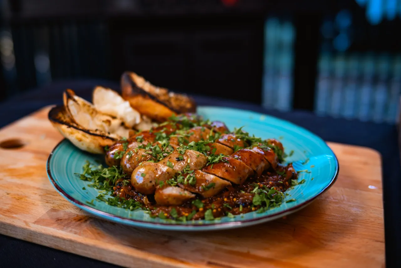 Kiełbasa marynowana w piwie z cebulą na grillu