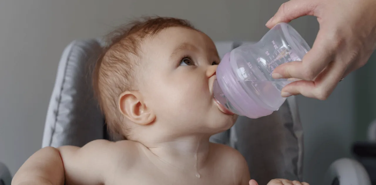 Rodzic podający dziecku wodę