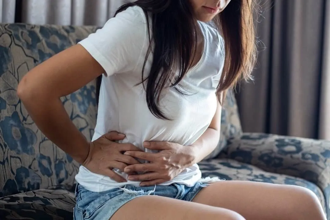 kobieta z bólem brzucha, nieregularny cykl, problemy z cerą