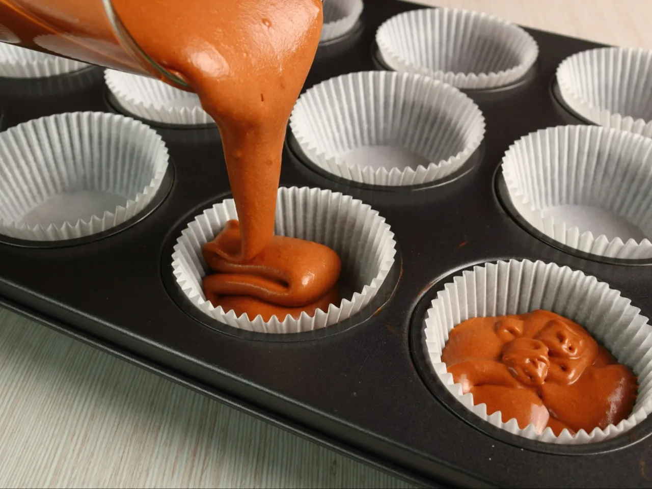 Napełnianie papilotek ciastem na babeczki