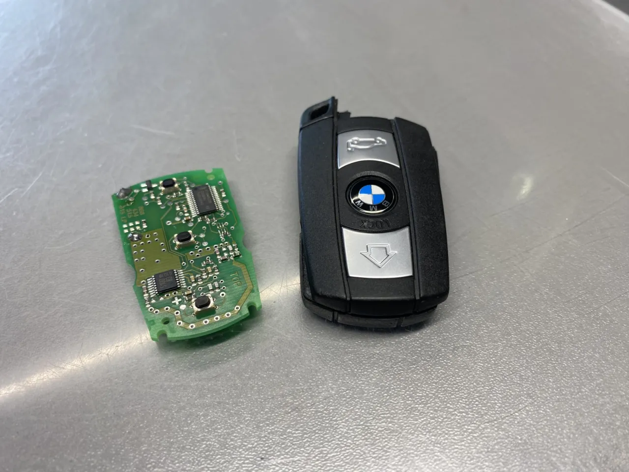 Rozłożony kluczyk BMW i jego płytka drukowana. Dowiedz się, jak wymienić baterię w kluczyku BMW.
