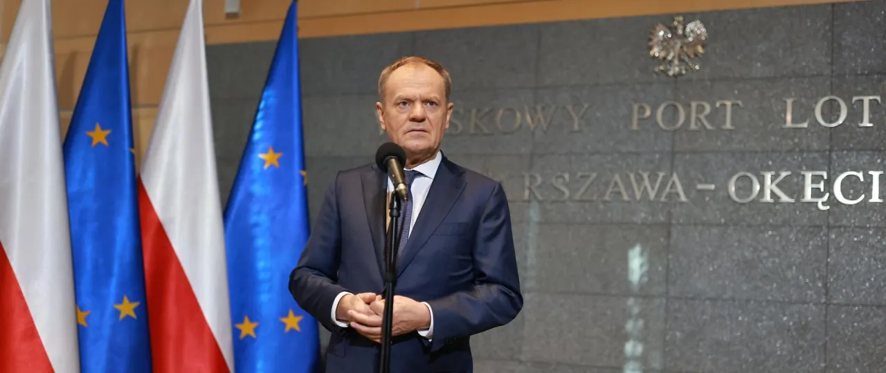 Donald Tusk, stojąc przed flagami Polski i UE, przemawia. Kto poparł zielony ład? On.