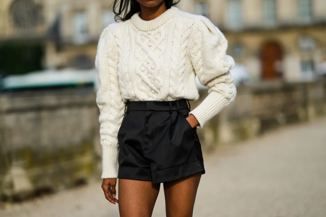 kobieta w białym swetrze i jeansach street style