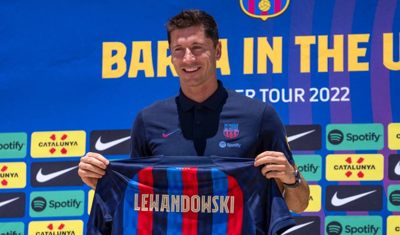 Robert Lewandowski prezentuje koszulkę FC Barcelona. Ciekawe, ile zarabia Lewandowski na miesiąc w nowym klubie.