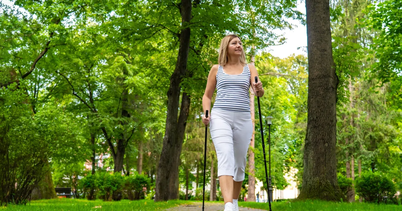 Osoba spacerująca w parku z uśmiechem
