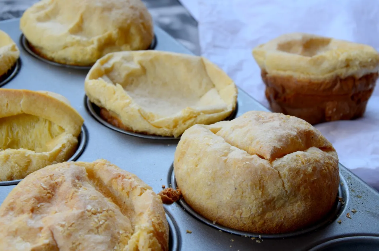 Puszyste, złociste babeczki w formie do pieczenia. Wyglądają jak idealne naczynie na słodki pudding.