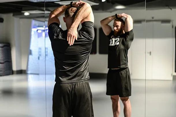 rozciąganie tricepsa z ręcznikiem lub gumą