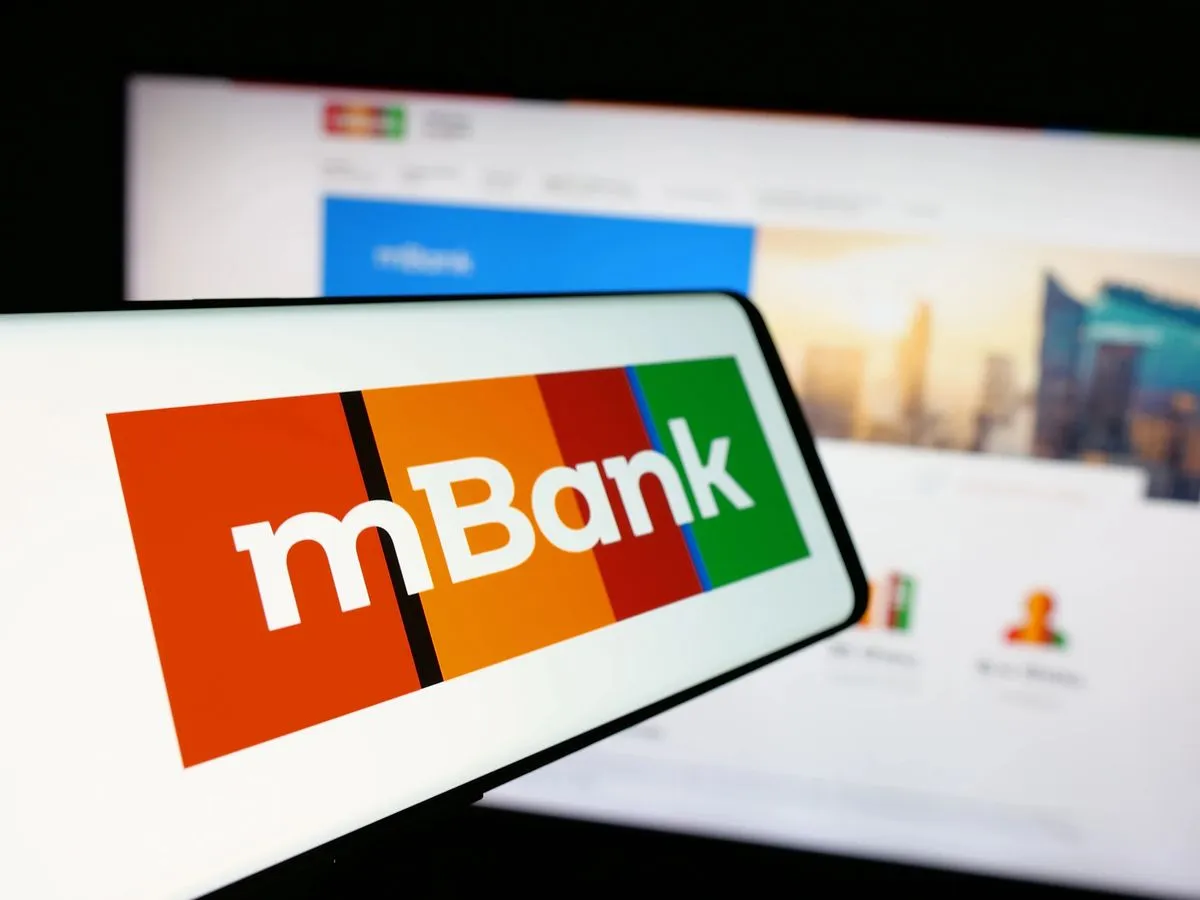 Logo mBank na ekranie telefonu, obok ekran komputera z widokiem strony banku. Szukasz informacji, jak spłacić kredyt odnawialny mBank?