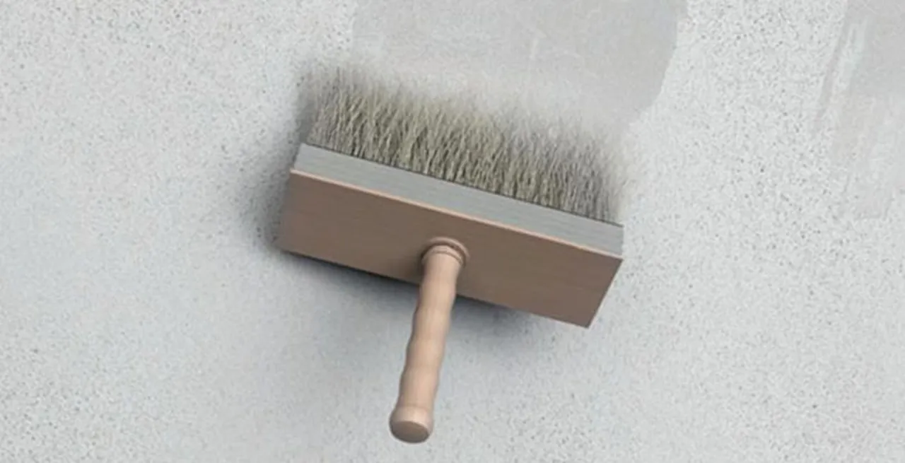 Pędzel do gruntowania na białej ścianie. Czy gładź można kłaść na farbę? Tak, po odpowiednim przygotowaniu podłoża.