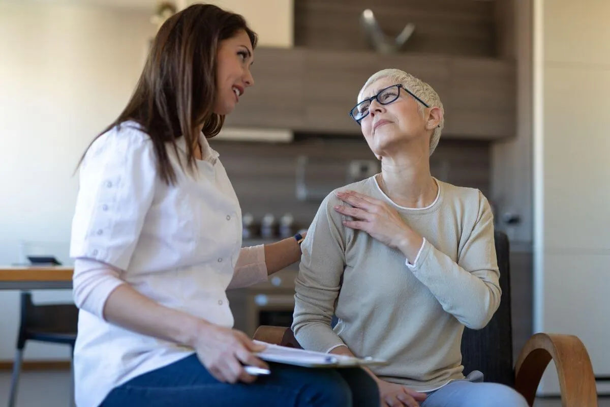 opiekunka rozmawiająca ze starszą osobą z empatią