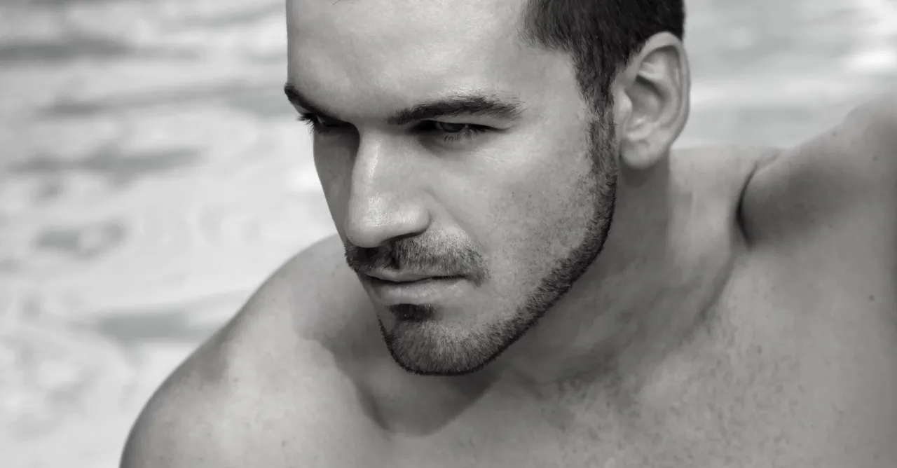 Zestresowany mężczyzna patrzący w lustro na źle przyciętą brodę