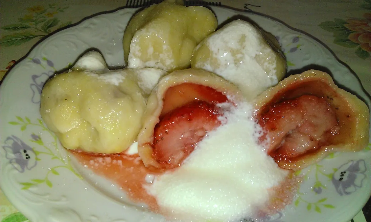 Pyszne pierogi z truskawkami i śmietaną, idealne po rozmrożeniu.