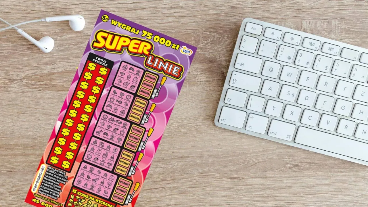 Super linie zdrapka o co chodzi? Na drewnianym biurku leży zdrapka Lotto 