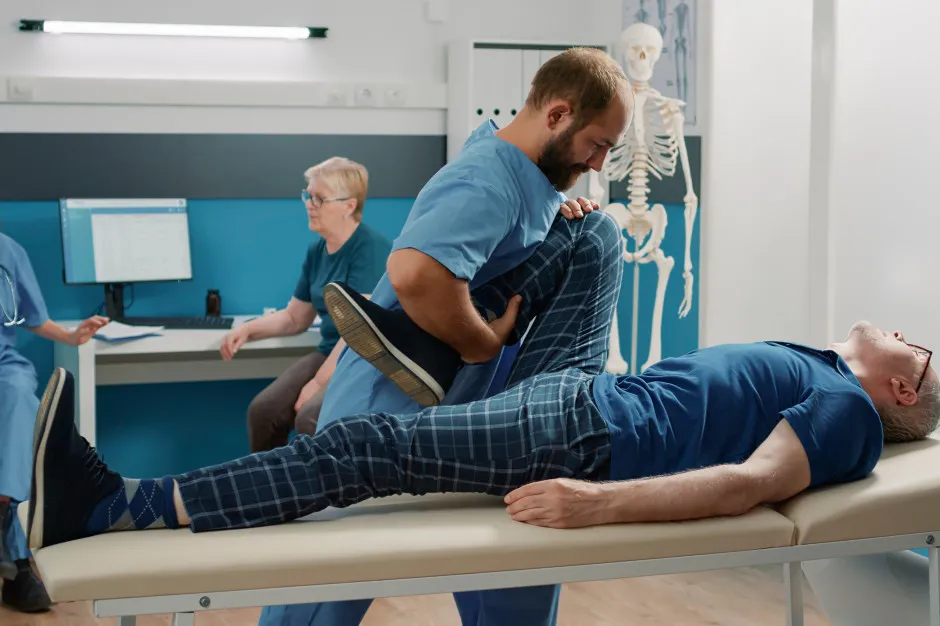 Fizjoterapeuta wystawiający e-ZLA lub fizjoterapeuta z pacjentem i komputerem