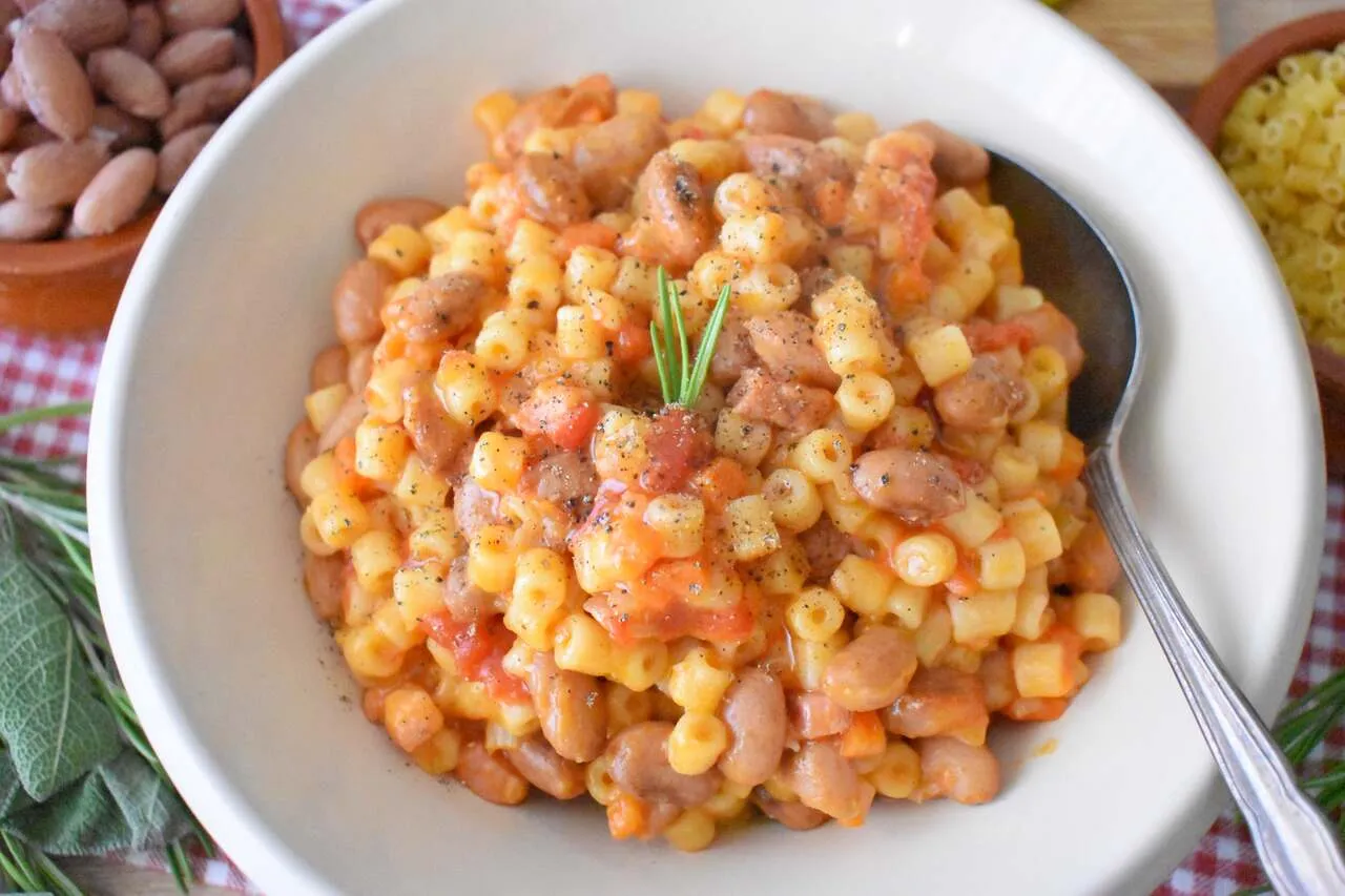 Pyszne danie Pasta e Fagioli przepis. Makaron z fasolą i pomidorami, doprawione pieprzem i gałązką rozmarynu.