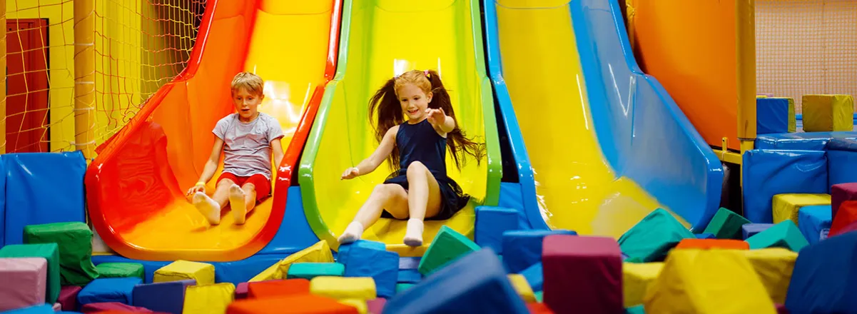 Kinder toben in einem bunten Indoor-Spielplatz