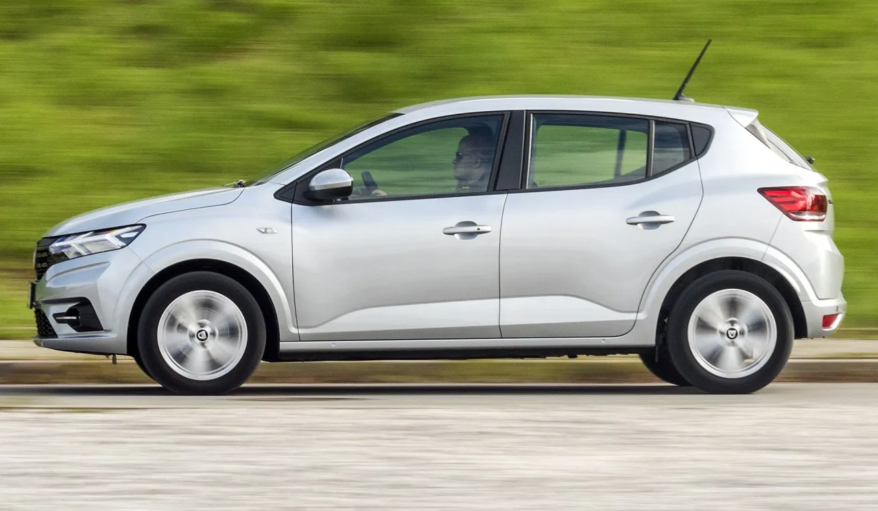 Srebrny samochód w ruchu, idealny na podróż. To najtańsze auto, które oferuje komfort i styl.