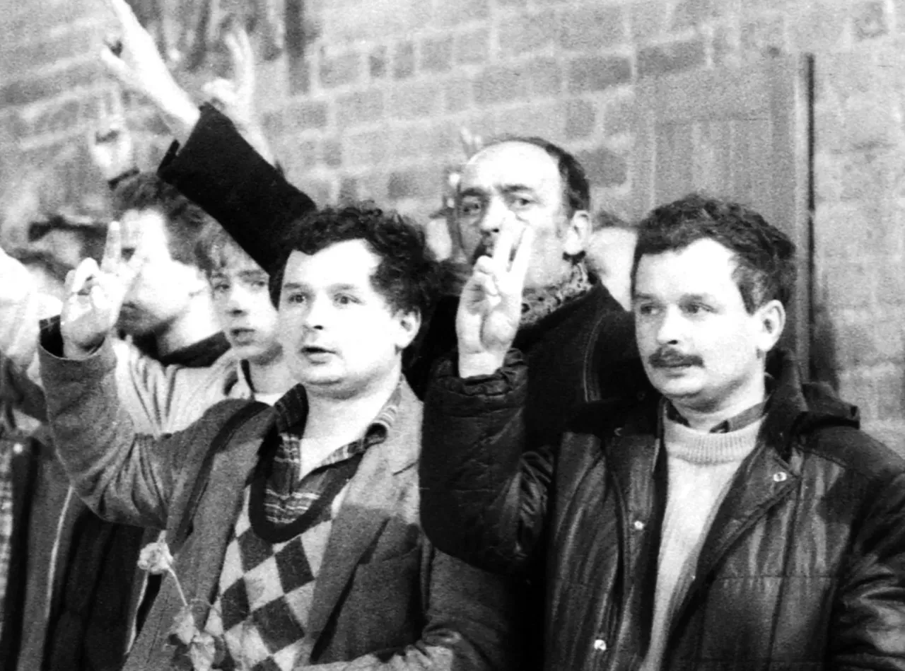 Jarosław i Lech Kaczyńscy z uniesionymi rękami, symbolicznie pokazując zwycięstwo. Rajmund Kaczyński o synach mówił o ich determinacji.