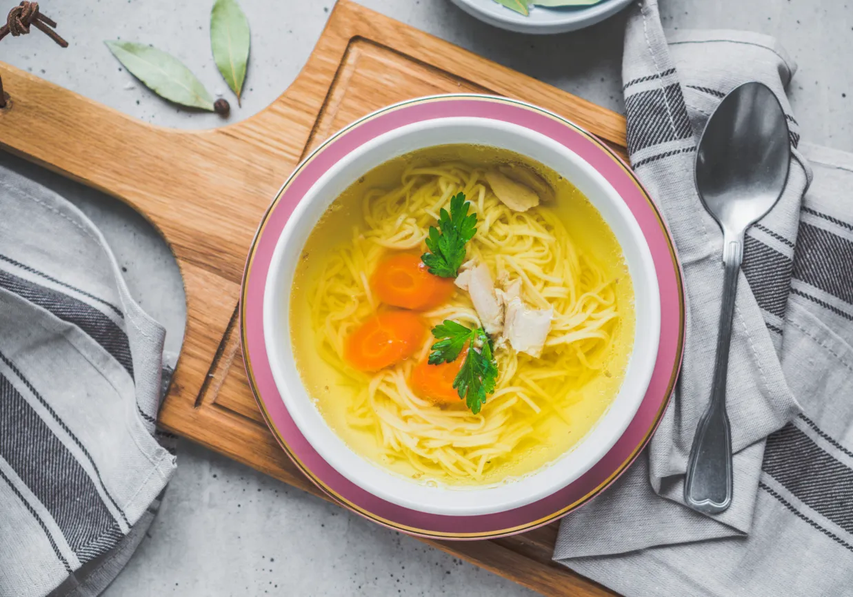 Ros&oacute;ł wołowo-drobiowy w misce z makaronem i natką pietruszki