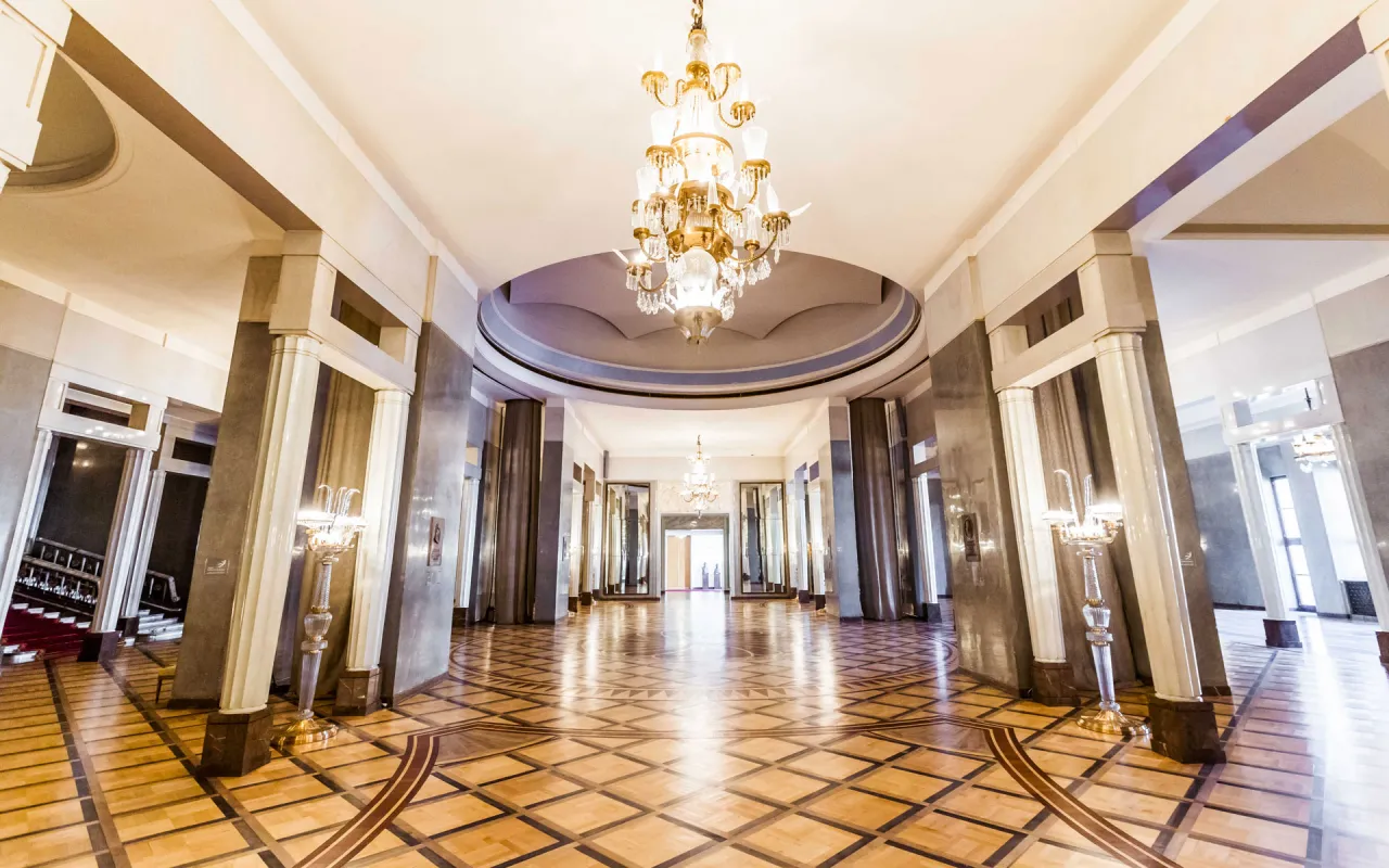 Eleganckie foyer teatru, z kryształowymi żyrandolami i parkietem, zaprasza do świata sztuki.