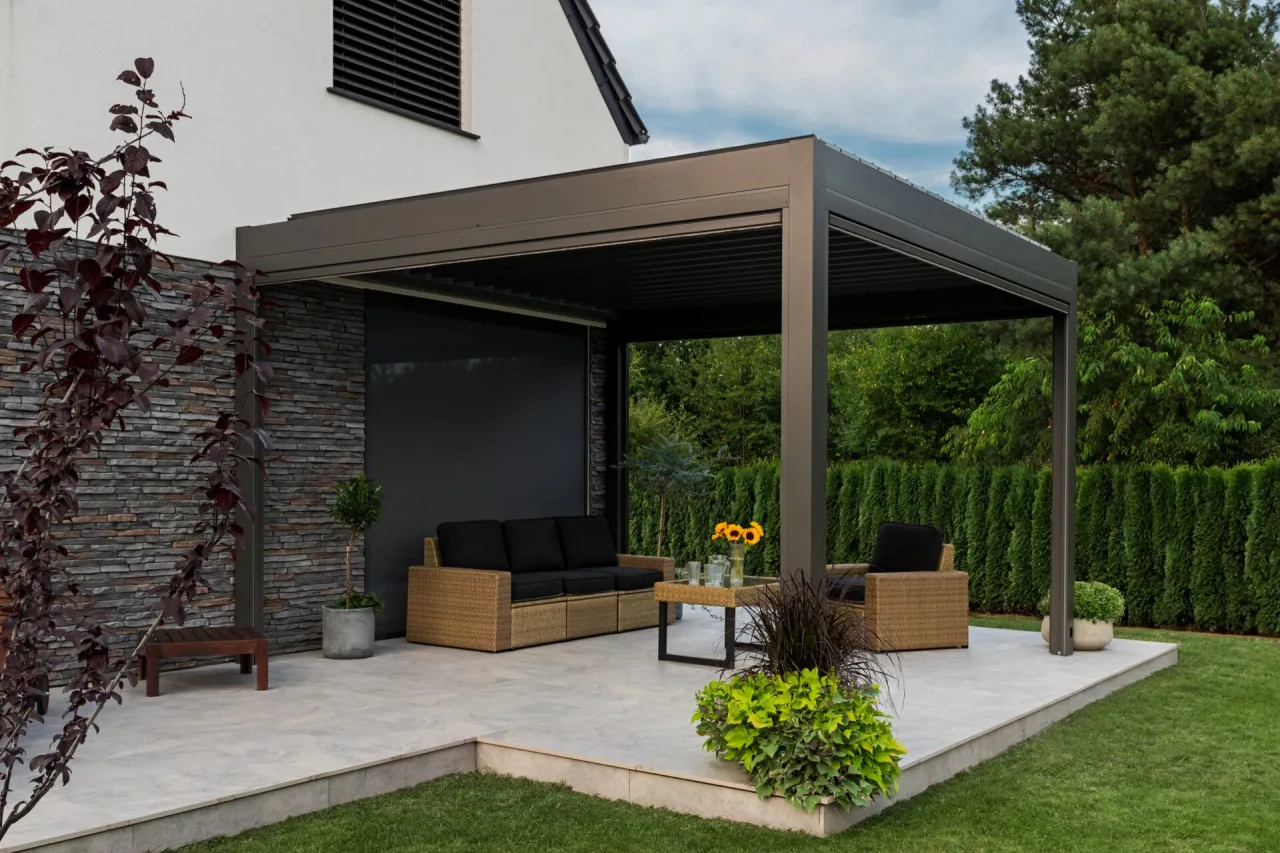 Nowoczesna pergola z meblami wypoczynkowymi. Zastanawiasz się, ile za zrobienie pergoli? To idealne miejsce na relaks.