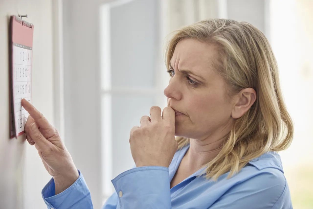 Kobieta z telefonem, zamyślona, z ukrytym ekranem