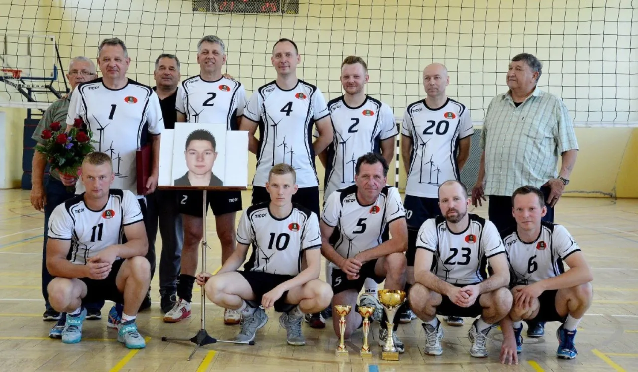 grupa dorosłych grająca w siatkówkę na hali sportowej