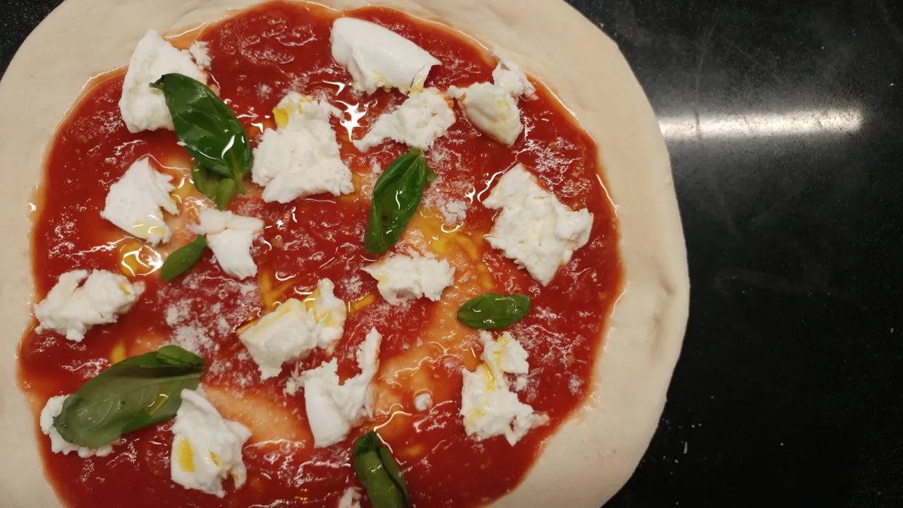 Niegotowa pizza Margherita, z sosem pomidorowym, mozzarellą i bazylią. Takie smaki narodziły się tam, gdzie powstała pizza &ndash; we Włoszech.