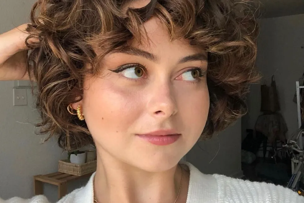 kobieta stylizująca kr&oacute;tkie loki