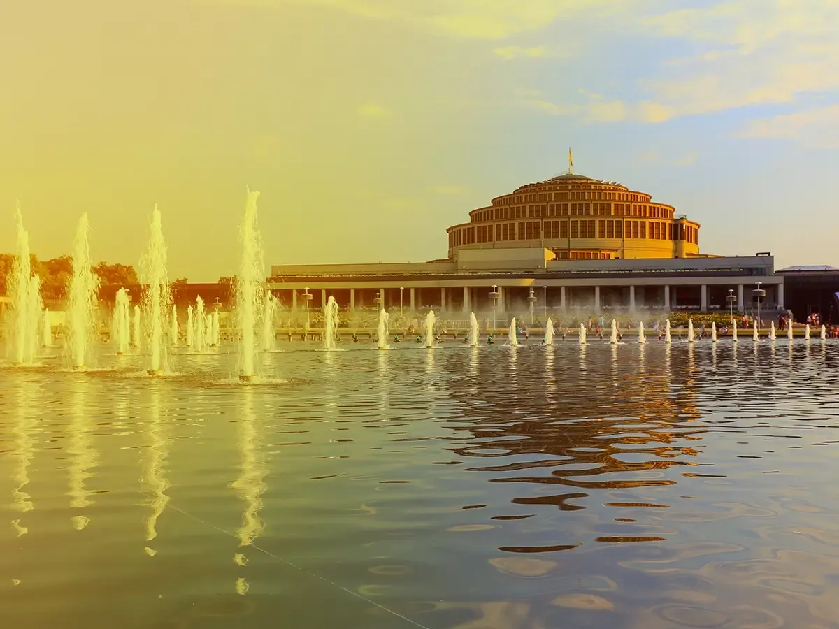 Fontanna przed Halą Stulecia, jednym z najpiękniejszych miejsc Wrocławia, w blasku zachodzącego słońca.