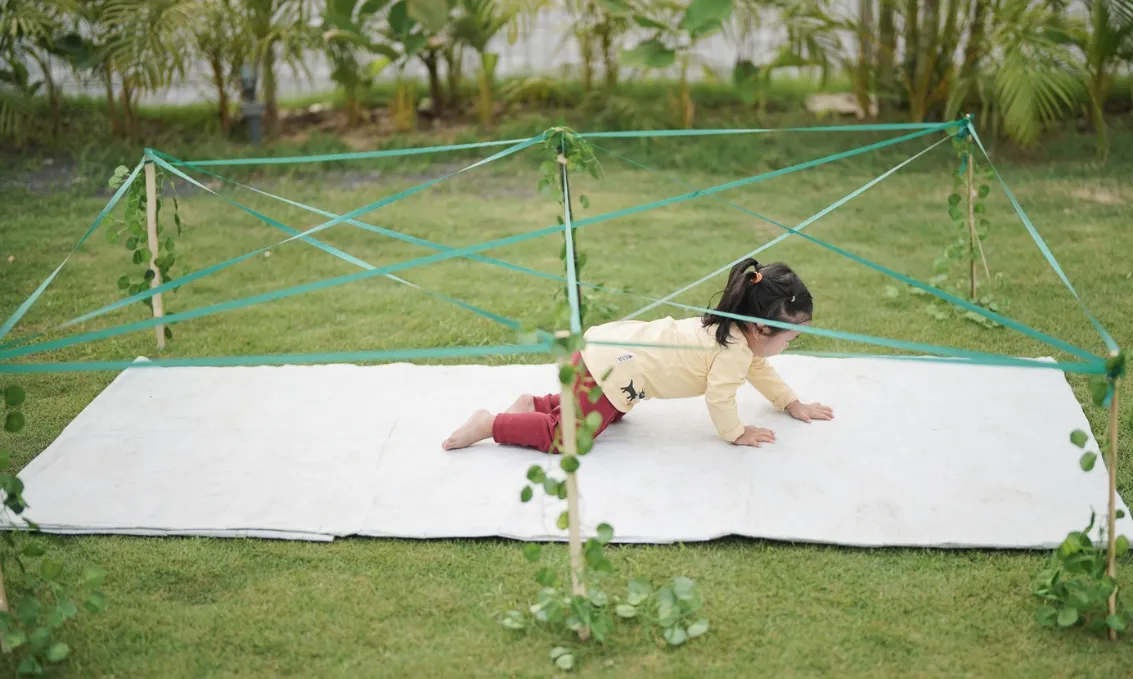dzieci budujące tor przeszkód w ogrodzie