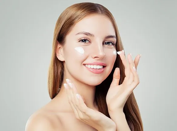 kobieta nakładająca krem z filtrem na jasną cerę