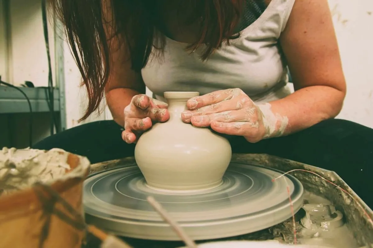osoba lepiąca z gliny na warsztatach ceramicznych w Krakowie