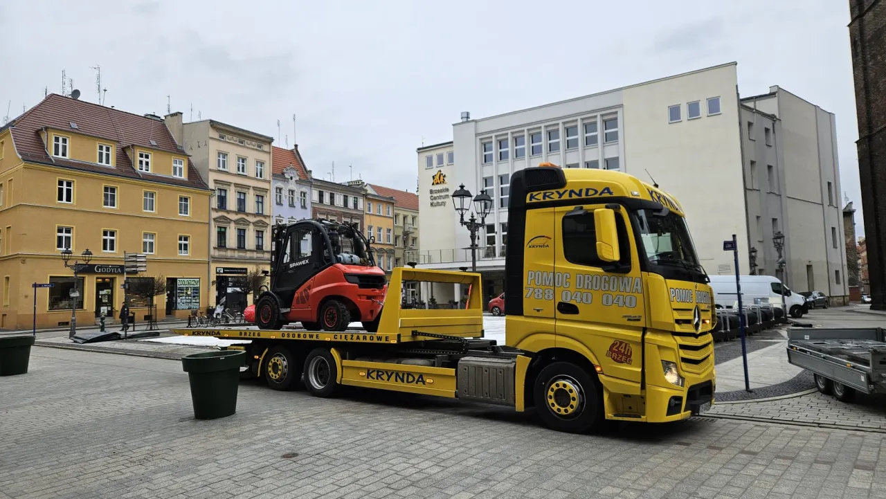 Ż&oacute;łta ciężar&oacute;wka pomocy drogowej KRYNDA z w&oacute;zkiem widłowym na lawecie. Usługa mtu assistance.