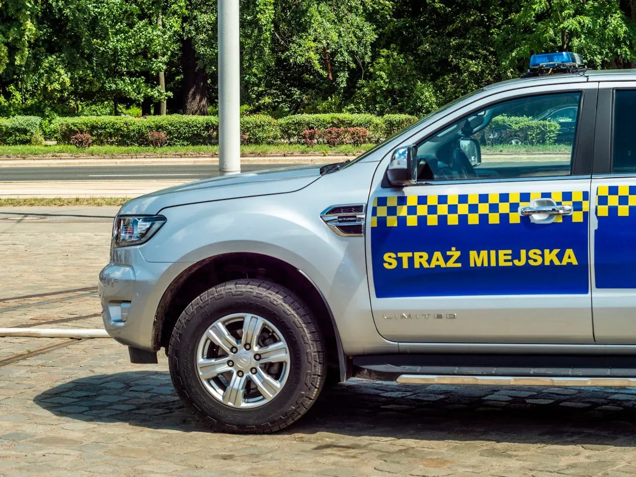 Srebrny radiow&oacute;z Straży Miejskiej z niebiesko-ż&oacute;łtymi pasami. Czy straż miejska może wystawić mandat? Tak, w określonych sytuacjach.