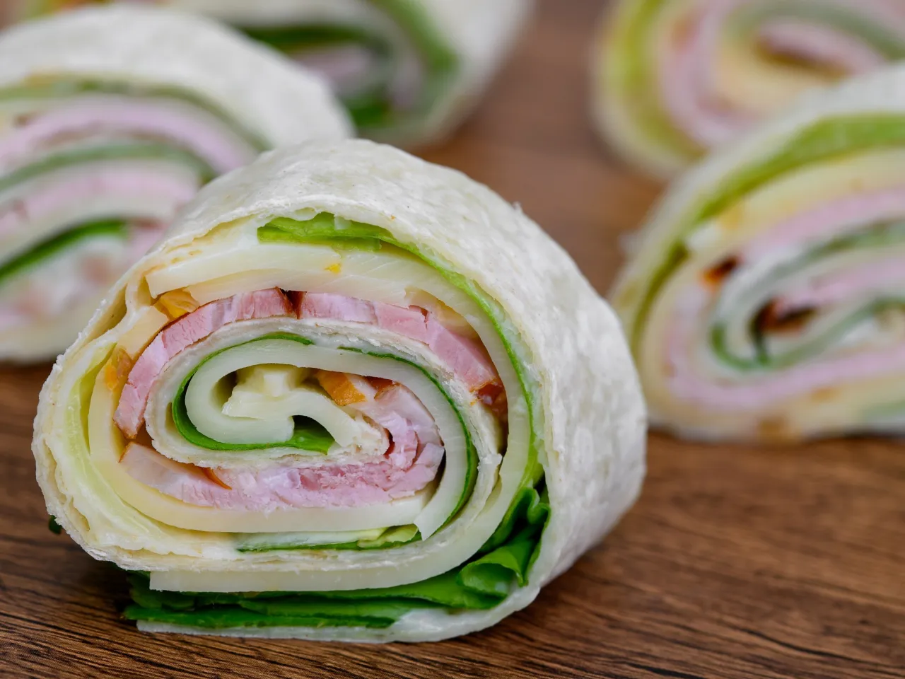 Roladki z tortilli z szynką, serem i sałatą to prosty sposób, jak zawijać tortille na przekąski.