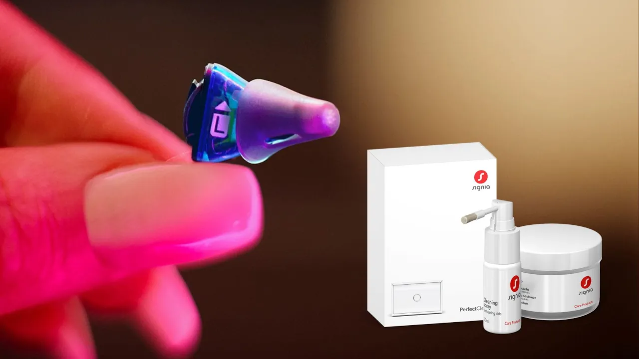 Dłoń trzyma aparat słuchowy. Obok zestawy do pielęgnacji: spray i pojemnik. Dowiedz się, jak czyścić aparat słuchowy.