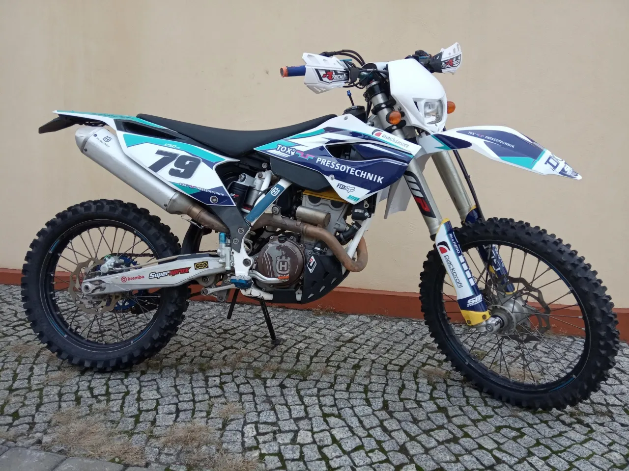 Husqvarna 250 Enduro z numerem 79, gotowy do jazdy po wyboistych trasach.