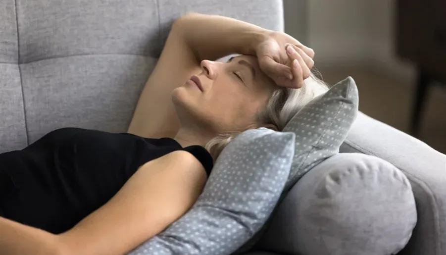 dorosła osoba zmagająca się z nadmiarem bodźców w zatłoczonym miejscu