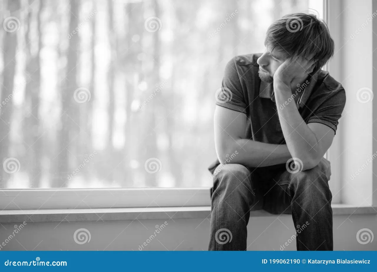 zamyślony mężczyzna patrzący przez okno